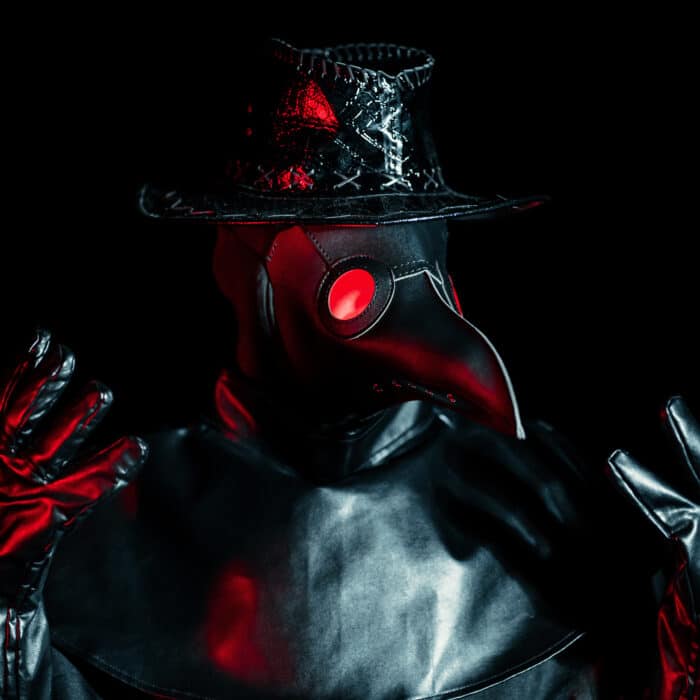 Portrait of plague doctor with crow-like mask isolated on black background. Creepy mask, halloween, historical terrible costume concept. Epidemic.