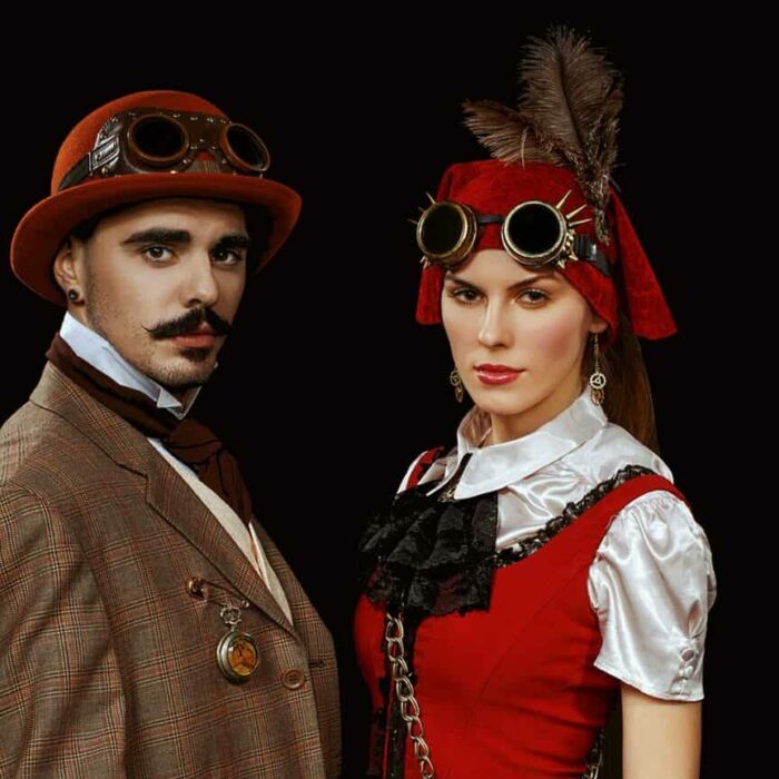 Low key portrait of a couple in steampunk clothes, glasses and cane